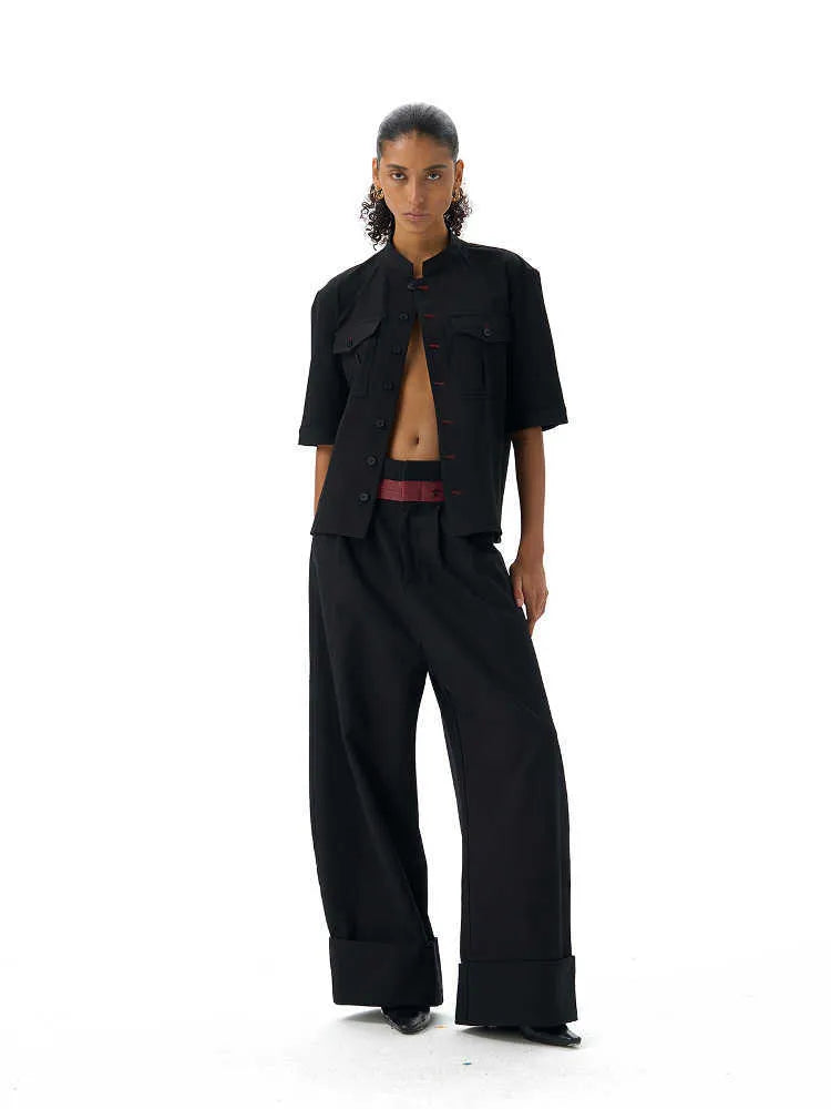 A black loose fit half sleeve hunting shirt with a shirt collar on a hanger.