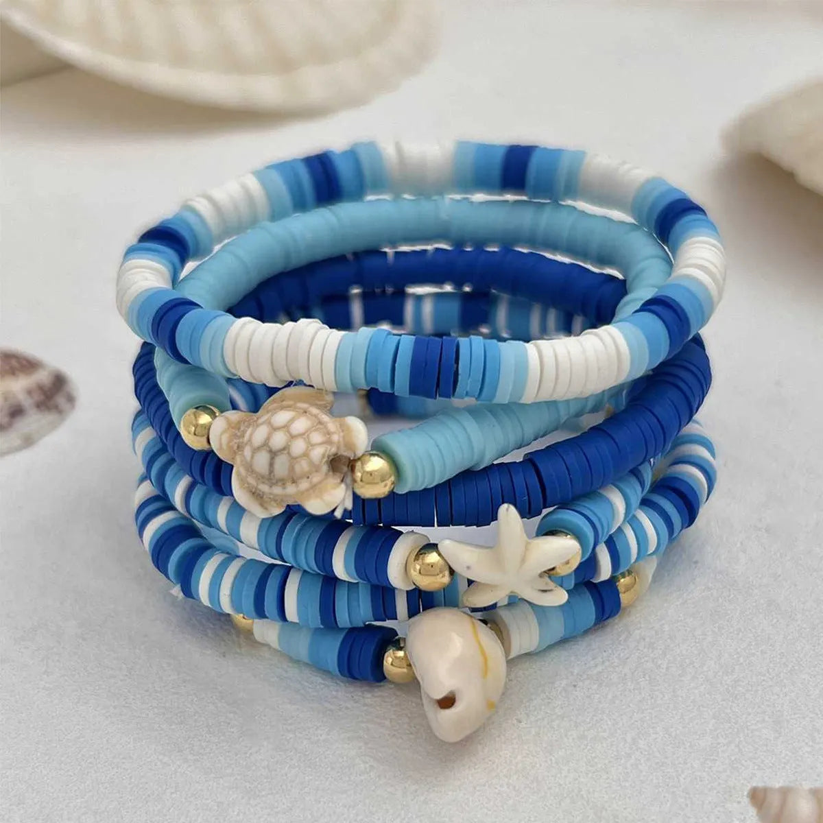 Set of six handmade bohemian polymer clay bracelets with shell and geometric designs in S3162 colour.