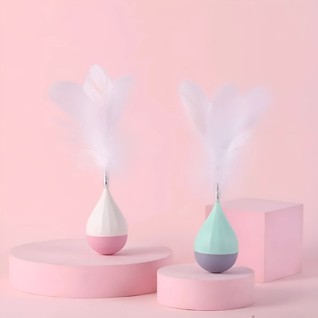 Feather tumbler cat toy with rolling ball and goose feather tease stick on a coloured background.
