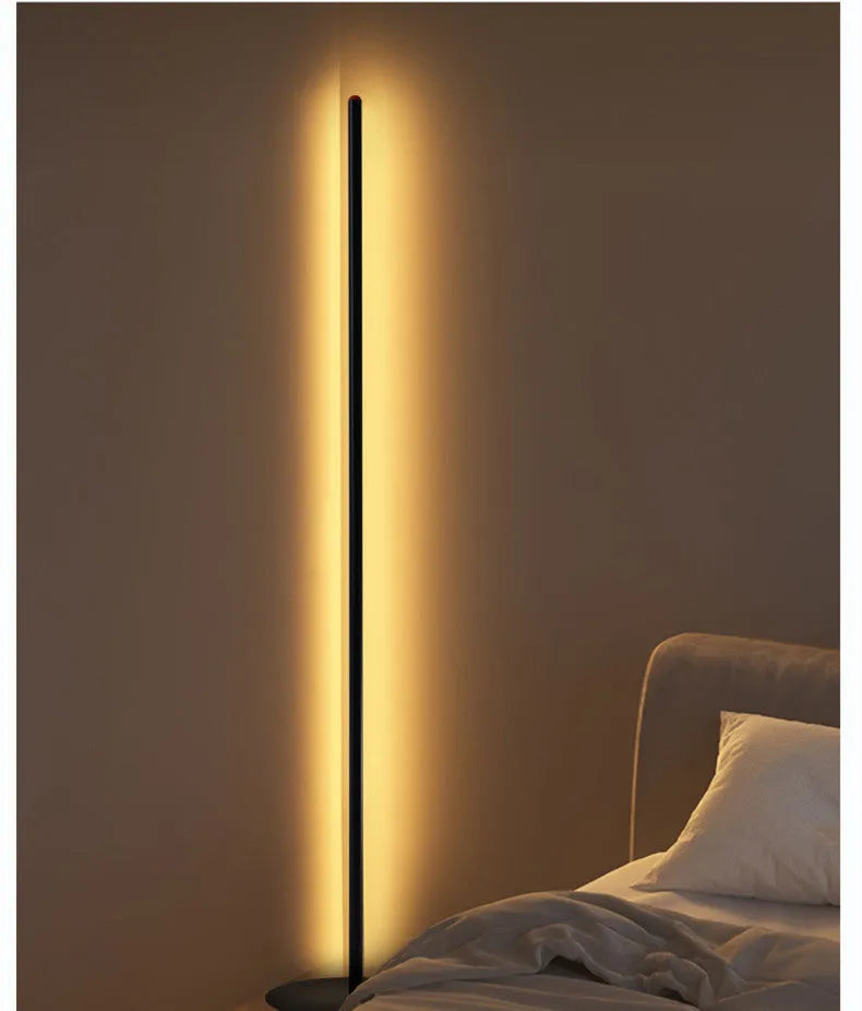 Simple vertical aluminium alloy floor lamp with a USB plug, shown beside a sofa.