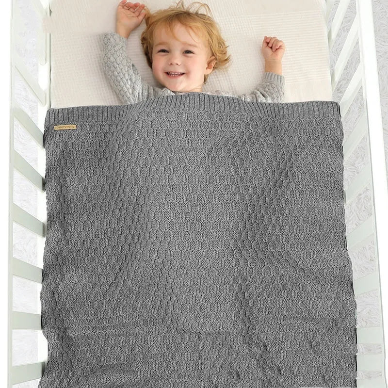 Solid colour infant hug blanket with textured three-dimensional lines pattern.