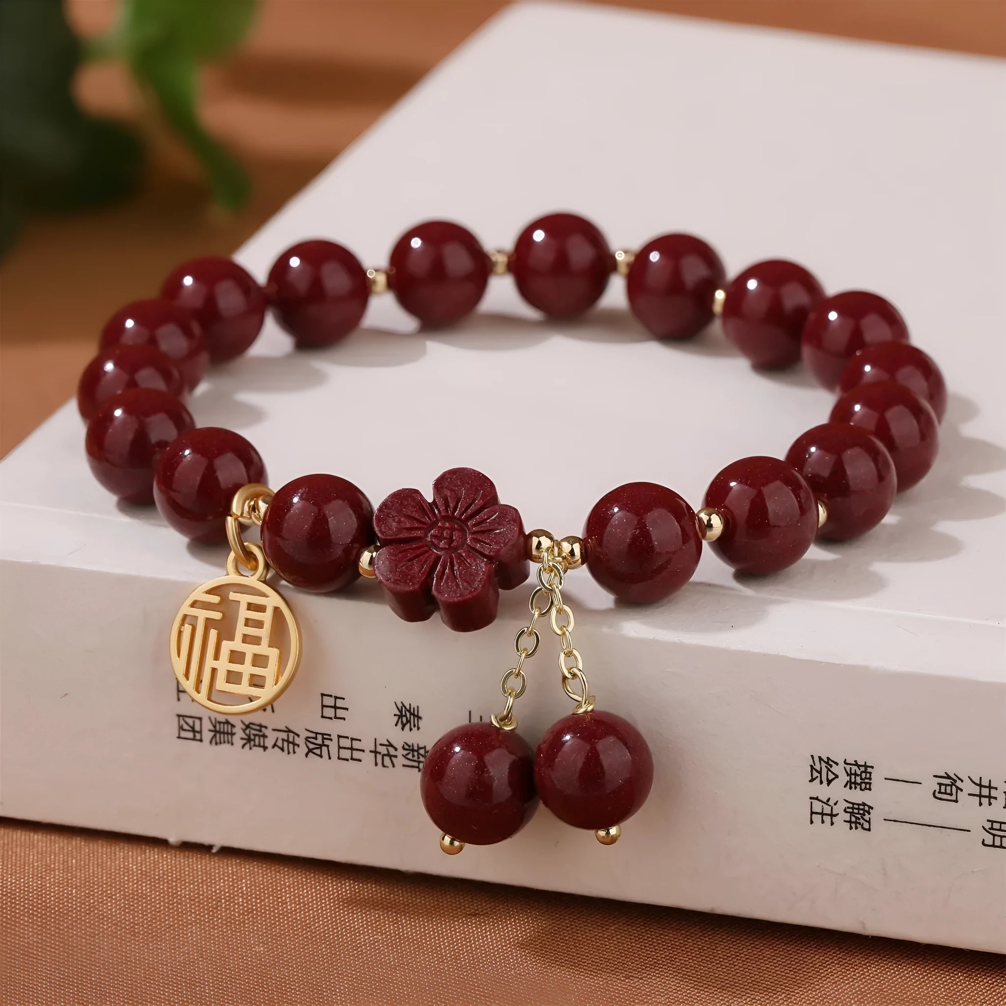 Women's cinnabar bracelet with Fu character charm and peach blossom tassels in purple gold sand colour