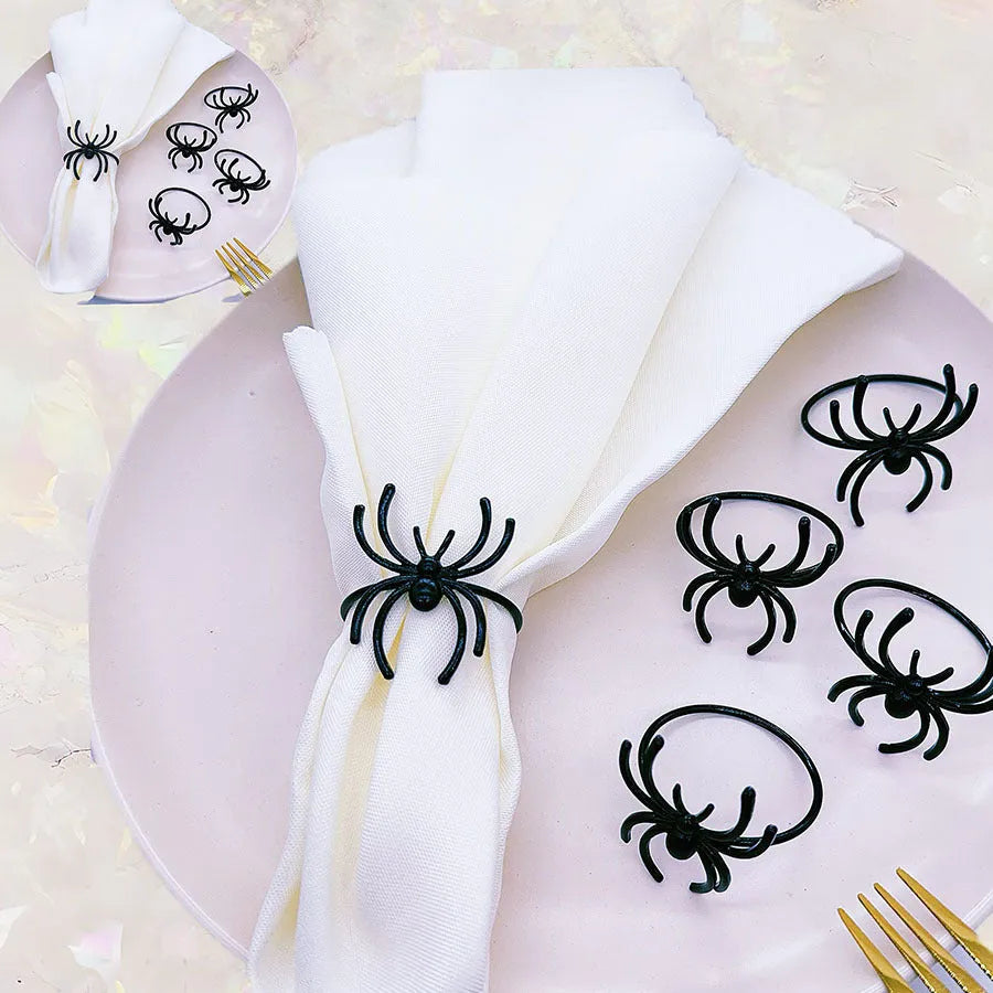 Set of six black alloy napkin rings with detailed spider sculpture for Halloween table decor.